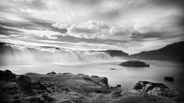 Waterfall rocks flowing black and white nature image.