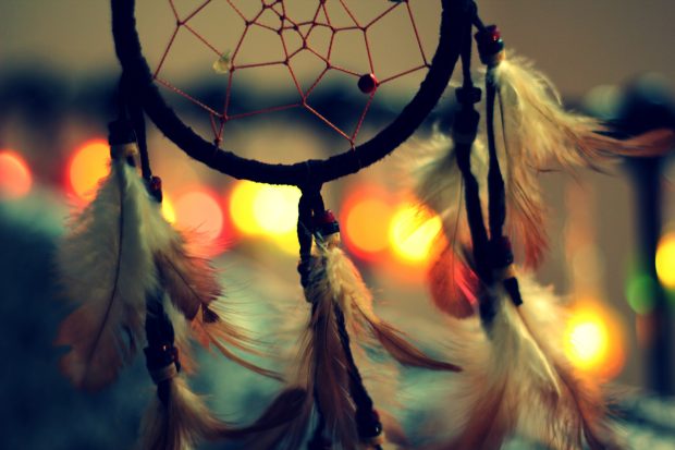 Macro of dreamcatcher on bokeh background amulets and talismans.