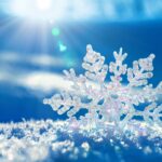 Frozen snowflake on snowy ground under bright sunlight in a winter landscape.