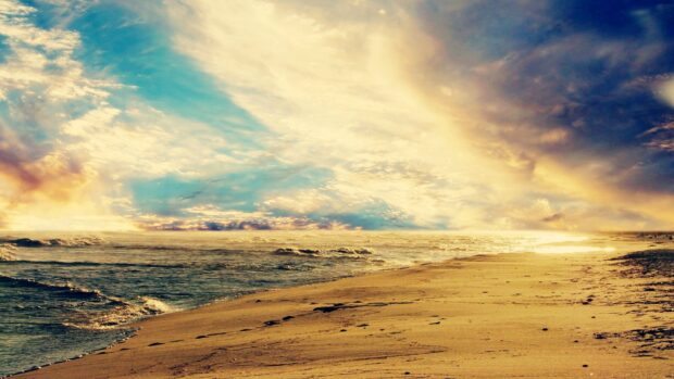 Sunset over sandy beach with ocean waves and colorful sky, creating a serene coastal scene for relaxation and travel.