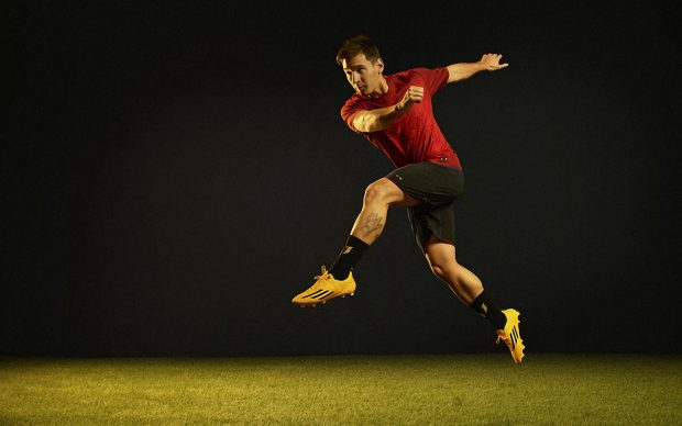 Leo Messi With Gold Adidas Soccer Adizero Boots Wallpaper.