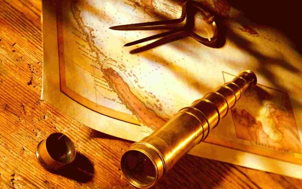 Brass telescope and navigational dividers on antique map