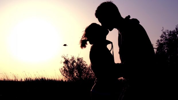 Couple shadow sunset kissing.