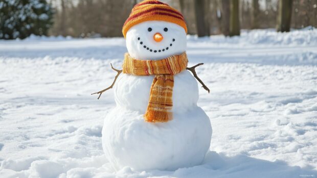 A snowman with an orange scarf and hat standing on snow in a winter setting