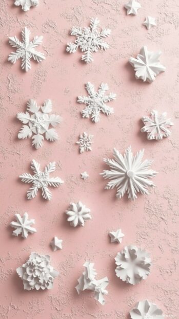 White snowflake decorations on a pink textured surface with aesthetic Christmas elements