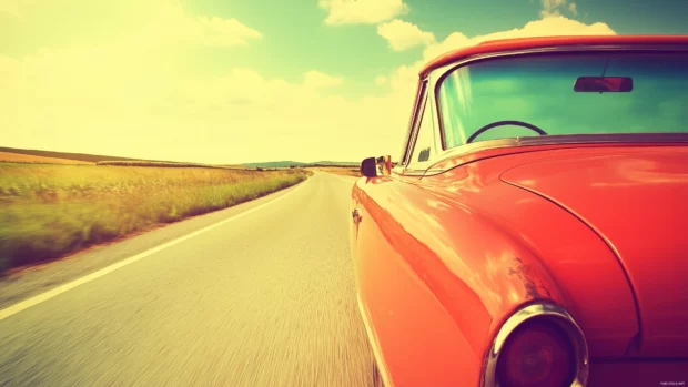 A vintage car driving through a lush countryside, with colorful retro signage on the roadsides and a bright, cheerful sky in the background.