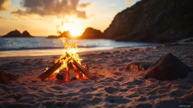 A beach bonfire burning brightly as the sun sets, casting a warm glow on the surrounding.