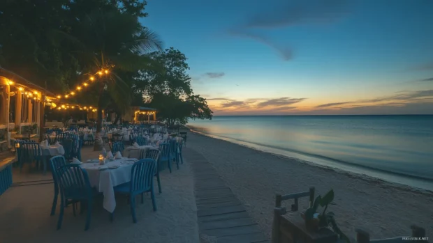 A beachside restaurant with outdoor seating, overlooking the ocean at sunrise with soft lighting.