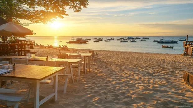 A beachside restaurant with outdoor seating, overlooking the ocean at sunrise, with soft lighting and a relaxed atmosphere.