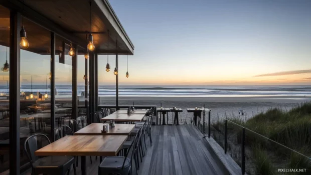 A beachside restaurant with outdoor seating, overlooking the ocean at sunrise, with soft lighting and a relaxed atmosphere.