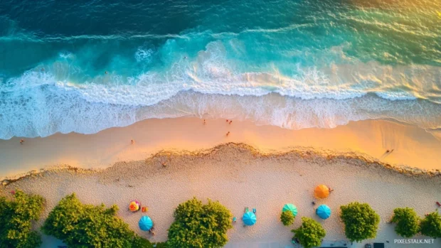 A bird eye view of a beach at sunrise, with colorful umbrellas and people enjoying the first moments of daylight.