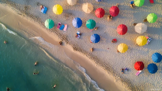 A bird eye view of a beach people enjoying the last moments of daylight.