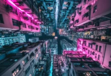 A bright Cyberpunk skyline featuring neon lit buildings and crowded roads under colorful lights.