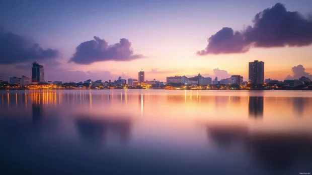 A calm evening cityscape with lights just beginning to flicker on.
