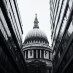 A cathedral dome contrasts with modern lines in city grayscale.