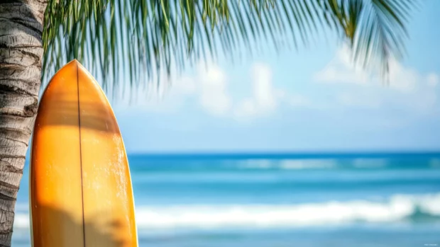 A close up of a surfboard leaning against a palm tree, with a blurred ocean background.