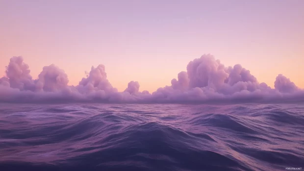 A dreamy evening sky over the ocean, with the horizon glowing in pastel pinks and lavenders as gentle waves roll in.