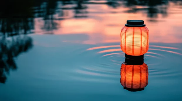 A glowing lantern floating in a calm lake at twilight, with subtle ripples reflecting the light.
