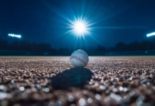 A night game scene, with bright stadium lights shining down on a lone baseball on the field.