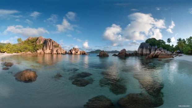 A panoramic view of a tropical beach at sunrise, with crystal clear water.