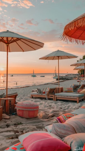 A preppy beach scene at sunset with colorful beach umbrellas and elegant beach chairs.