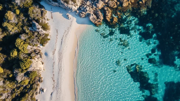 A pristine beach with crystal clear turquoise waters and white sand .