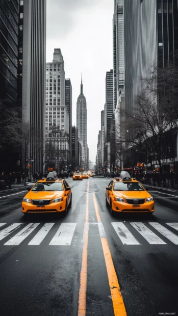 A quiet New York City street with just a few yellow cabs passing by.