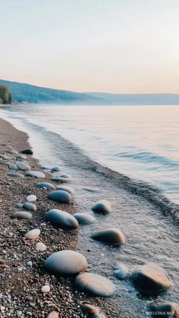 A quiet aesthetic beach with smooth pebbles and a misty, pastel colored sky.