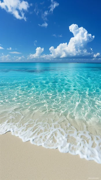 A serene beach with turquoise waters and powdery white sand.
