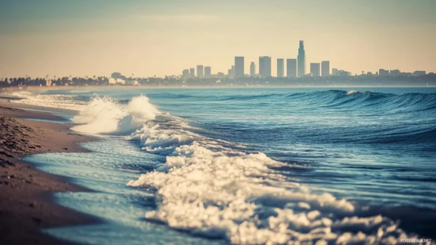 A simple Los Angeles beach scene with gentle waves, sandy shores, and a hint of the city skyline in the distance.