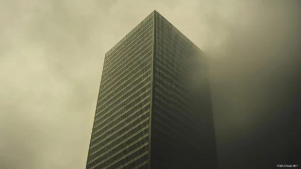 A single skyscraper standing tall against a calm, cloudy background.