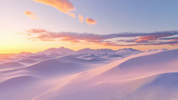 A snowy landscape under an evening sky, with the snow reflecting warm orange and pink tones as the sun sets.