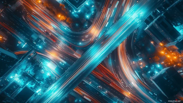 Aerial night view of city lights and busy roads.