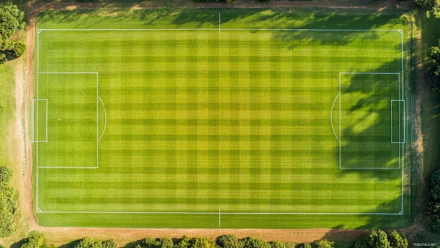 An aerial view of a classic baseball field, perfectly manicured grass and precise chalk lines .