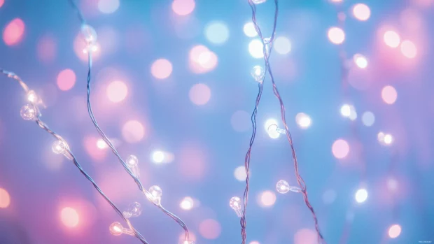 An array of glowing fairy lights in pastel hues, delicately arranged against a blurred soft focus background.