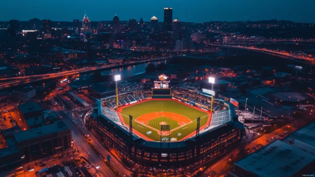 Birds eye view of baseball stadium surrounded by city lights.