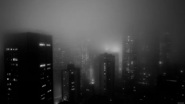 Blending noir and sci fi in a compelling Dark City Wallpaper, dim light and fog.
