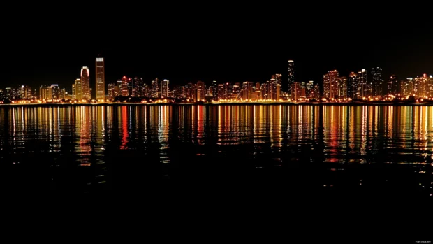 City lights shimmer on calm Lake Michigan waters, panoramic night Chicago skyline.