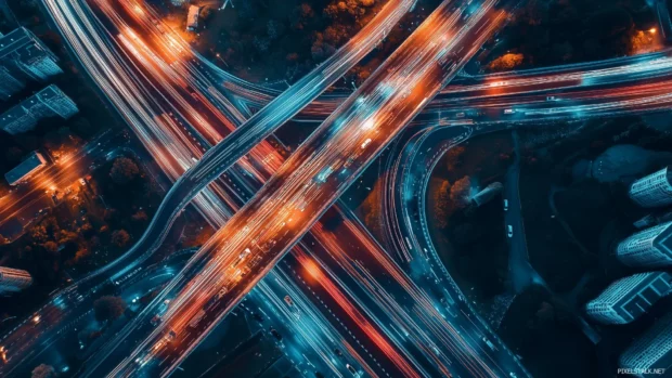 City view from above with glowing lights and traffic trails.