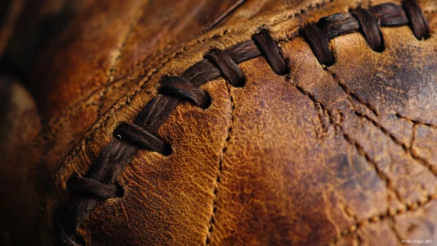 Close up of a worn baseball glove with visible stitching.