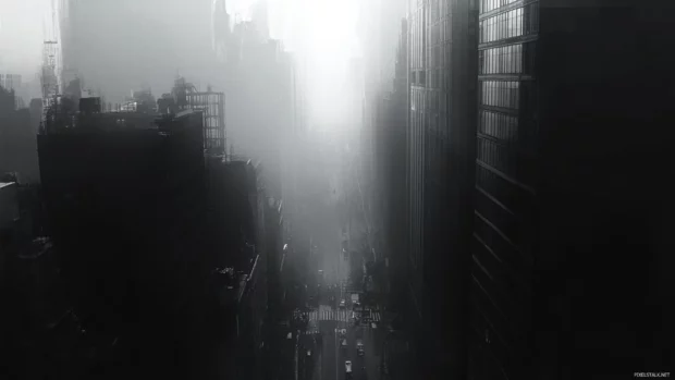 Crisscrossing streets fade into mist across grayscale city view.