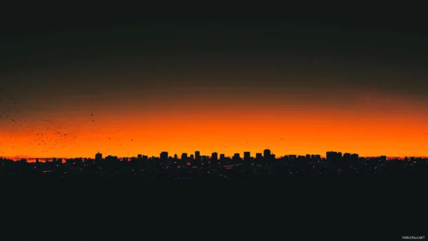 Faint orange glow outlines the black city horizon.