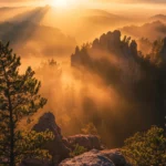 Golden beams illuminate rocky outcrops in this Mountain Sunrise wallpaper.