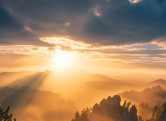 Golden beams illuminate rocky outcrops in this Mountain Sunrise wallpaper.
