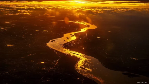 Golden light over a winding river at sunrise.