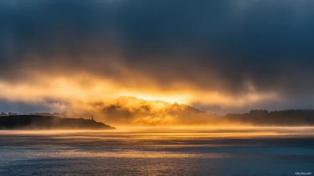 Golden rays piercing through heavy clouds at sunrise.