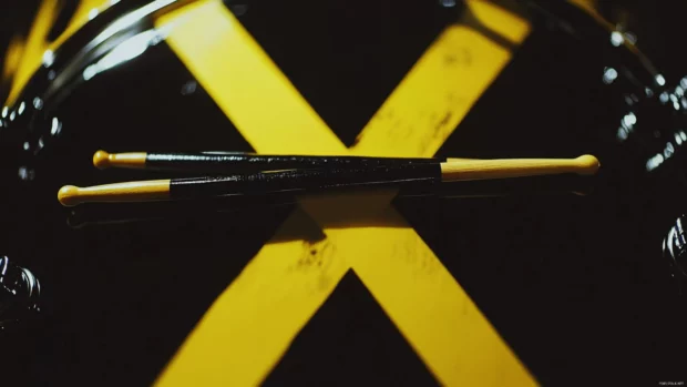 High contrast image of drumsticks over snare drum.
