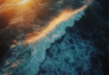 Layers of light and shadow play on ocean waves during sunrise.