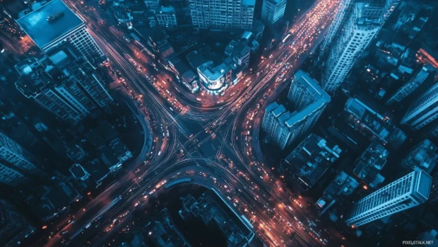 Modern cityscape at night seen from above with light patterns.
