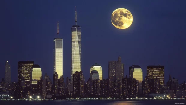New York City towers glisten under the moonlight.